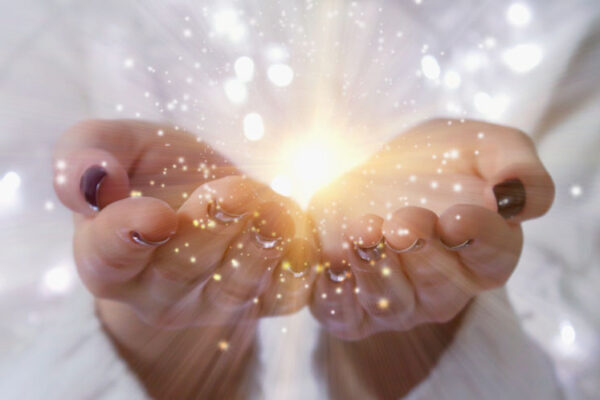 Magic particles on the palms of a woman, the flow of magical energy emanating from female hands