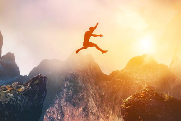 Man jumping between rocks to represent overcoming a problem