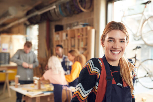 Small Startup Business Owner In Workshop Assembling Hand Built Bamboo Bicycles
